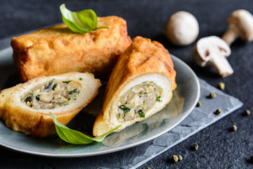 Fried rolls coated in batter and stuffed with mushroom, cheese, onion and parsley   