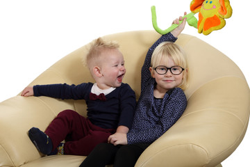 Śliczne rodzeństwo, brat i siostra bawią się na fotelu. © Stanisław Błachowicz