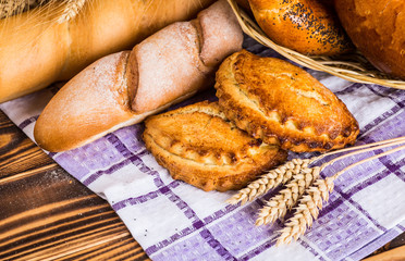 Assortment of baked bread on wooden table background