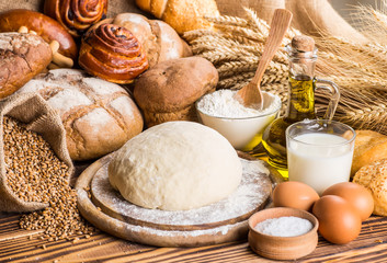 Assortment of baked bread on wooden table background