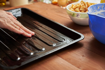 hand lubricates the baking dish