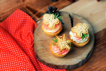 Christmas cookies are on the cream top of cupcake. Posted cutting the tree.