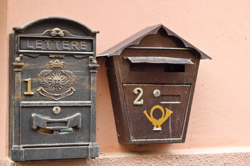 Two vintage post boxes mailboxes on pink wall