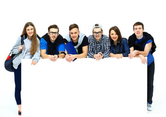 Full length portrait of confident college students displaying blank billboard against white background