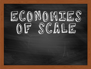 ECONOMIES OF SCALE handwritten text on black chalkboard