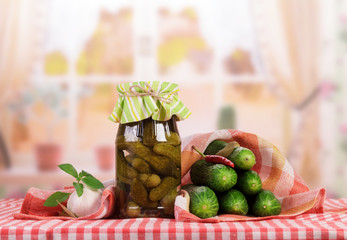 Fresh and jar with pickled cucumbers, spices on background kitchen.
