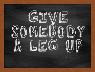 GIVE SOMEBODY A LEG UP handwritten text on black chalkboard