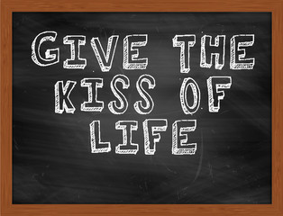 GIVE THE KISS OF LIFE handwritten text on black chalkboard