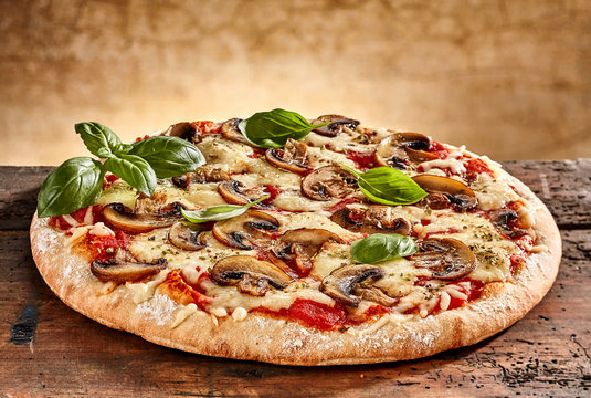 Delicious small pizza with mushrooms and basil
