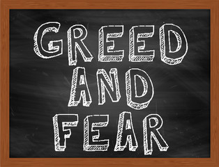 GREED AND FEAR handwritten text on black chalkboard © Ionut  Catalin Parvu