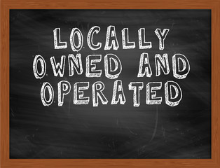 LOCALLY OWNED AND OPERATED handwritten text on black chalkboard