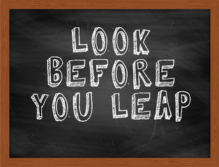 LOOK BEFORE YOU LEAP handwritten text on black chalkboard