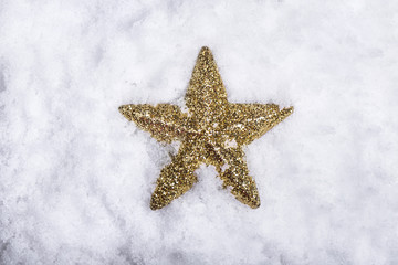 Fototapeta na wymiar Gold star placed in snow