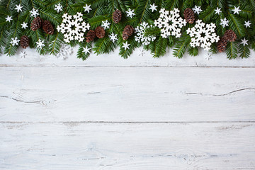 Christmas wooden background with branches, trees, cones, snowflakes
