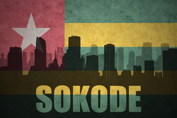 abstract silhouette of the city with text Sokode at the vintage togo flag