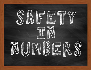 SAFETY IN NUMBERS handwritten text on black chalkboard