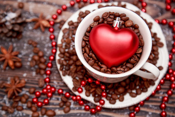 Heart shape toy and cup on Christmas wooden background.