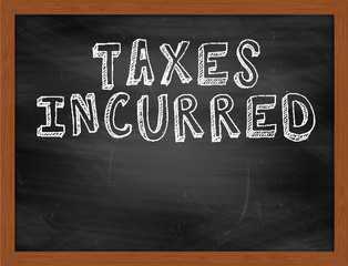 TAXES INCURRED handwritten text on black chalkboard