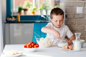 The boy mixing white cheese in bowl for cheesecake