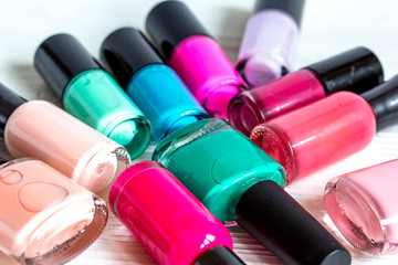 bottles of colored nail polish on wooden background