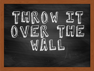 THROW IT OVER THE WALL handwritten text on black chalkboard
