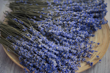 Lavender flower branches are on the wooden plate. Beautiful lavender is on the picture
