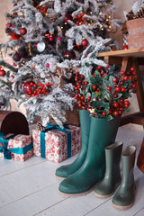 green rubber boots under the Christmas tree, autumn interior, autumn decoration