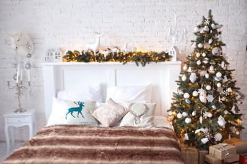 Christmas tree with a white bed in a white room