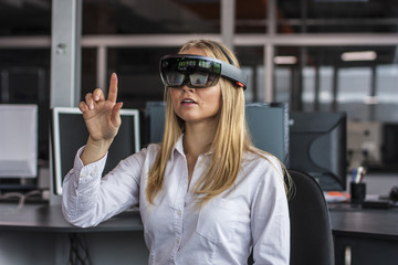 Virtual reality device. Woman playing game in virtual reality glasses. Headset  with virtual screen. Girl touch something using modern glasses with virtual screen