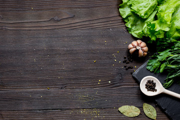 Obraz na płótnie Canvas spices and fresh salad on dark wooden table top view