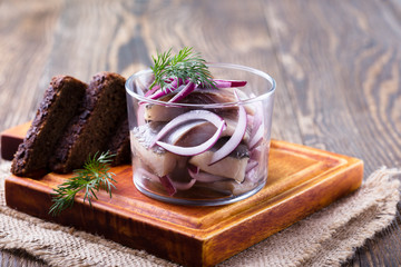 Appetizer food, herring in a glass and rye bread