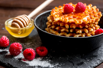 waffles with raspberries on wooden background