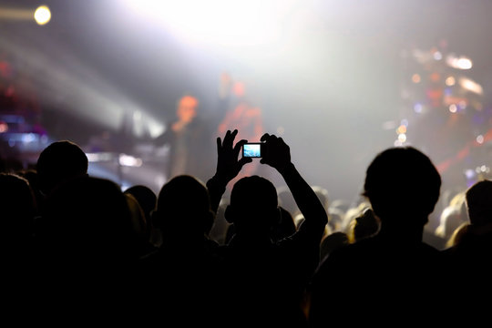 Music concert with audience and man doing photo