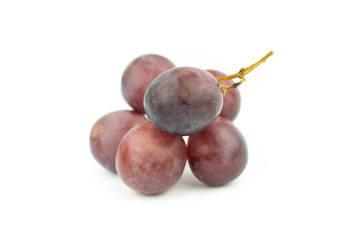 Ripe red grape with leaves isolated on white