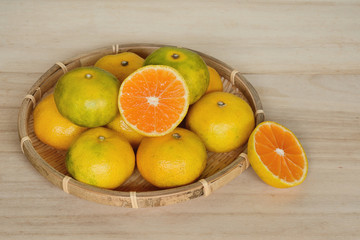 ザルに入ったミカン　木目背景　　
