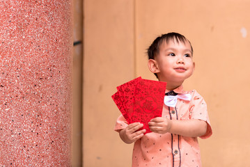   boy hold red envelope or Ang-pow . The kid smiling because of