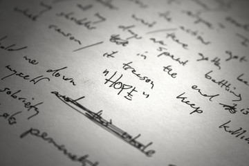 Lyrics written on paper in black ink close up. Focus on the word "HOPE"