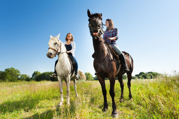 Two young women riding their beautiful horses