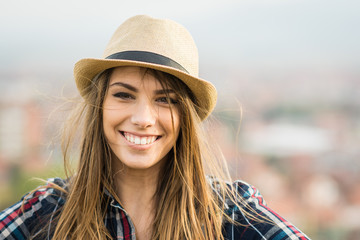 Beautiful young blonde woman in brown fedora hat smiling
