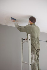 Man painting facade builder worker with roller