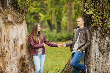 Young couple are enjoying therig time together in a park on a beautiful Autumn day.