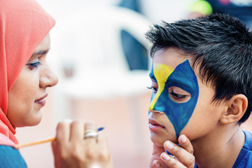 Boy child young having his face painted for fun at a birthday party - Powered by Adobe