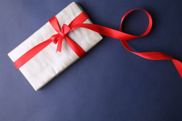 White present gift with red ribbon on blue background