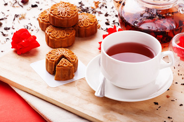 Chinese mid autumn moon cake festival foods. Traditional Chinese dessert on table setting with teacup.