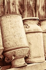 Vintage Rustic Metal Milk Cans Leaning On a Barn