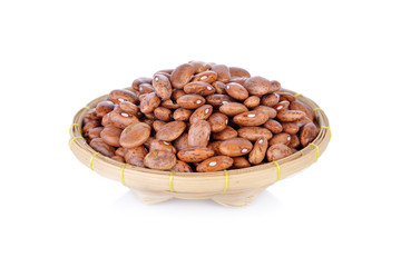 uncooked pinto beans in bamboo basket on white background