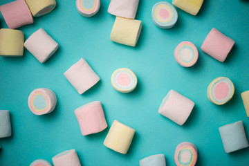 Top view of pastel colored marshmallow on a blue background. Min