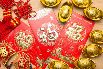 Chinese red envelope and gold ingot in wood