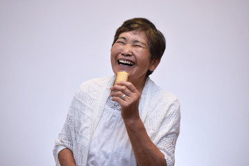 お菓子を食べる60代女性のイメージ