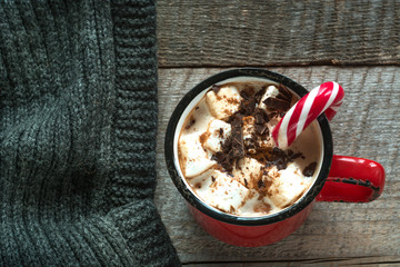 Christmas drink. Hot chocolate with marshmallows and candy cane on the wooden background. Hot cocoa with marshmallows. New Year. Holiday card. Rustic style. Close up.